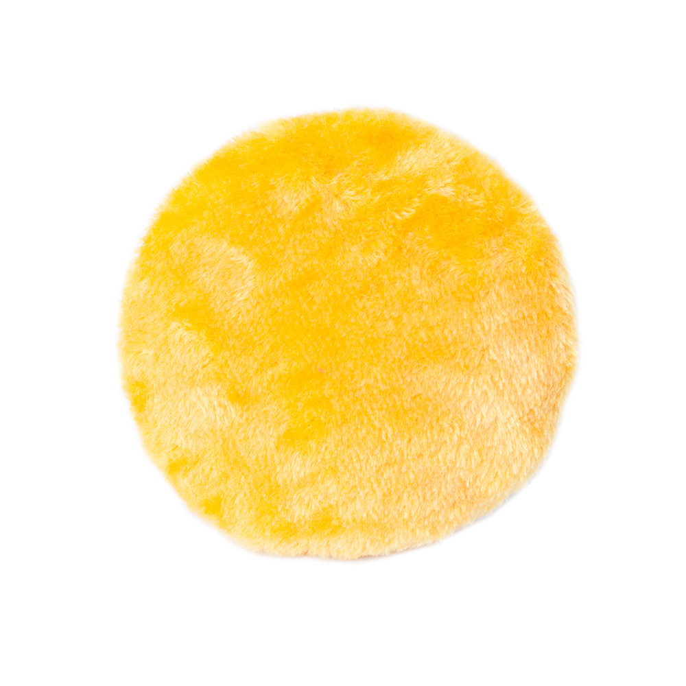 A circular, fluffy yellow object with a slightly uneven texture resembling a soft, plush pad or cushion.