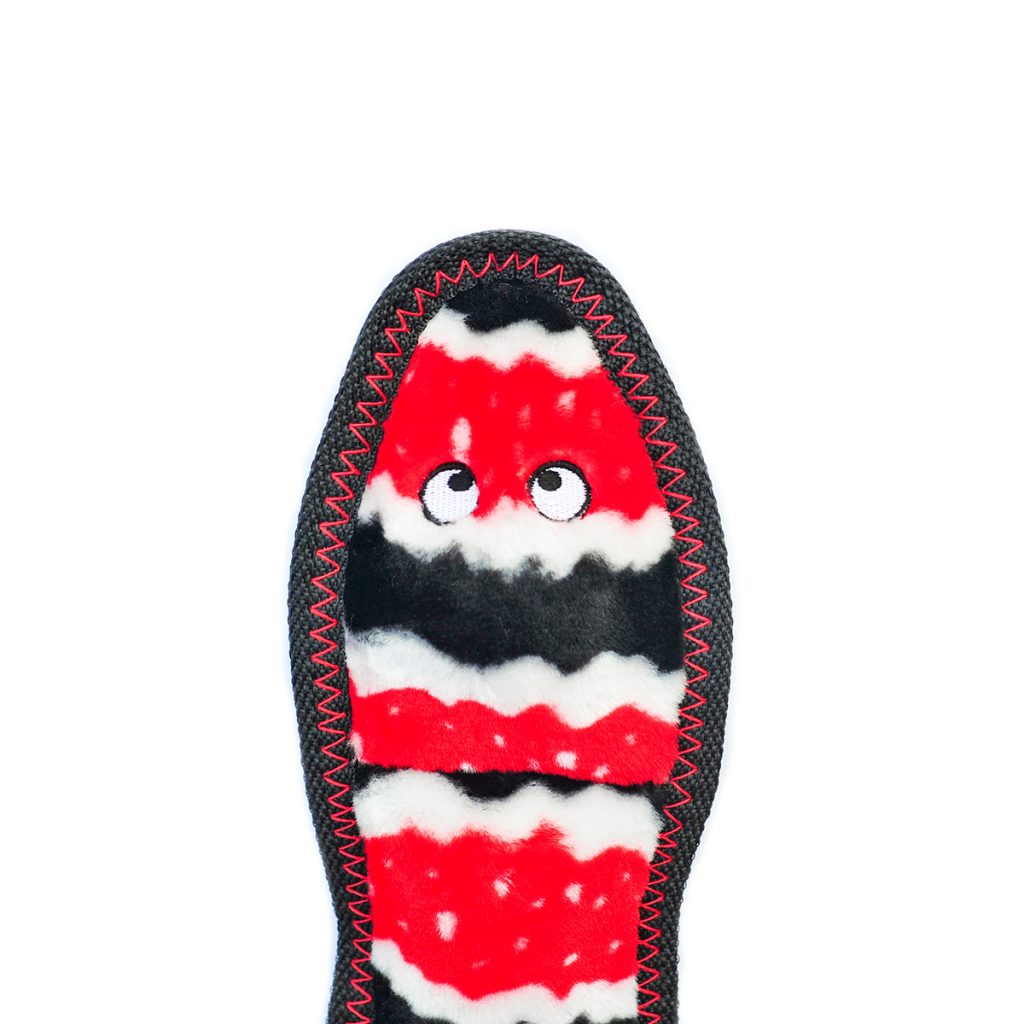 The image shows the sole of a colorful slipper with a wavy red, black, and white pattern and two small white eyes near the top.