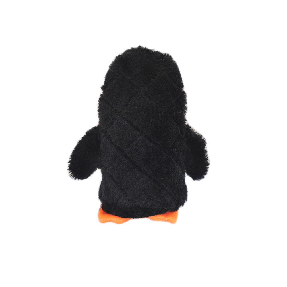 A plush toy resembling a penguin stands upright with its back facing. The toy has black fur, orange feet, and small wings.