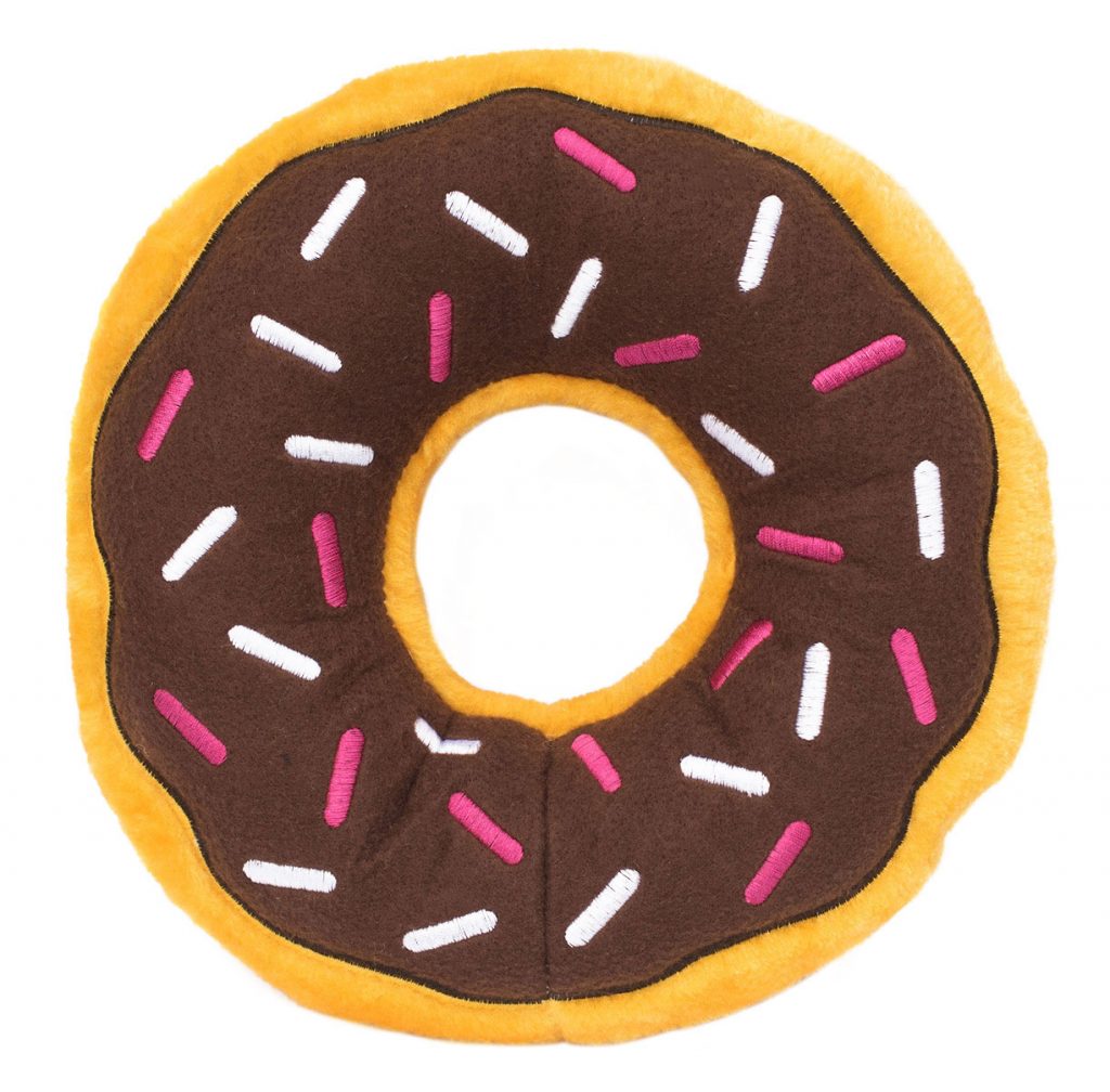 A plush toy shaped like a donut with a brown top, colorful sprinkles, and an orange edge.