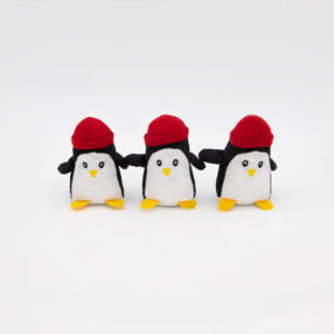 Three small Miniz 3-Pack Penguins with yellow feet, white bellies, and red hats are lined up side by side on a white background.