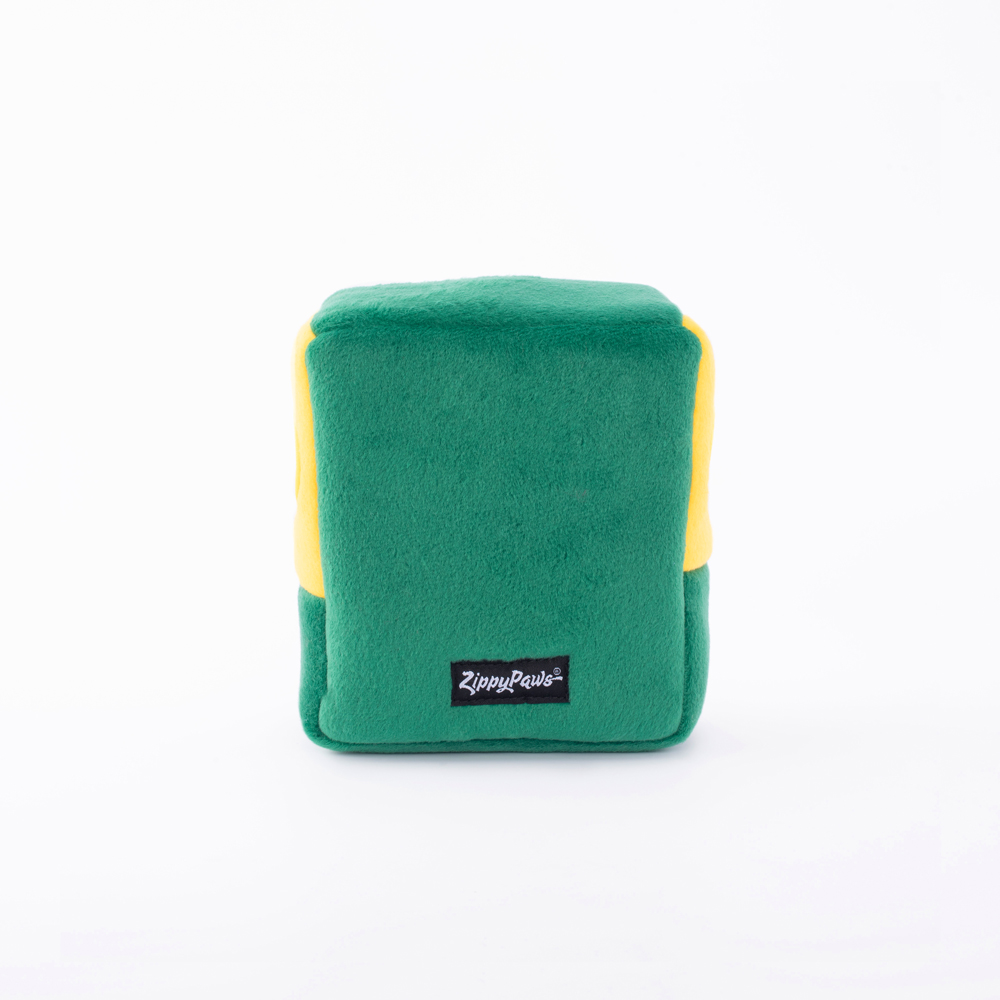 A plush, cube-shaped dog toy with green and yellow panels, featuring a 