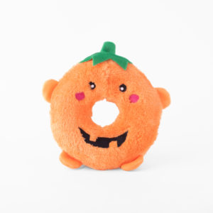 A plush orange toy shaped like a donut with a smiling face and small green leaf on top.