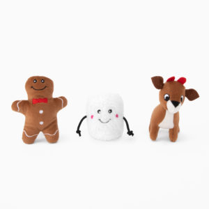 Three plush toys are arranged side by side: a gingerbread man with a red bow tie, a smiling marshmallow with black arms, and a reindeer with red horns.