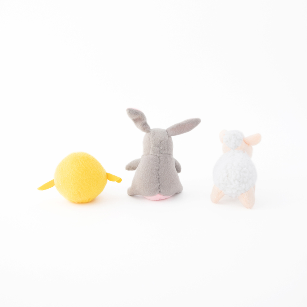 Three plush toys are placed side by side from left to right: a yellow bird, a grey bunny, and a white sheep, all viewed from the back against a plain white background.