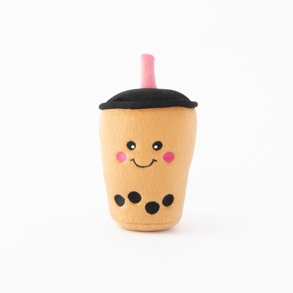 A plush toy designed to look like a smiling boba tea cup, featuring a light brown body, black lid, pink straw, and black tapioca pearls.