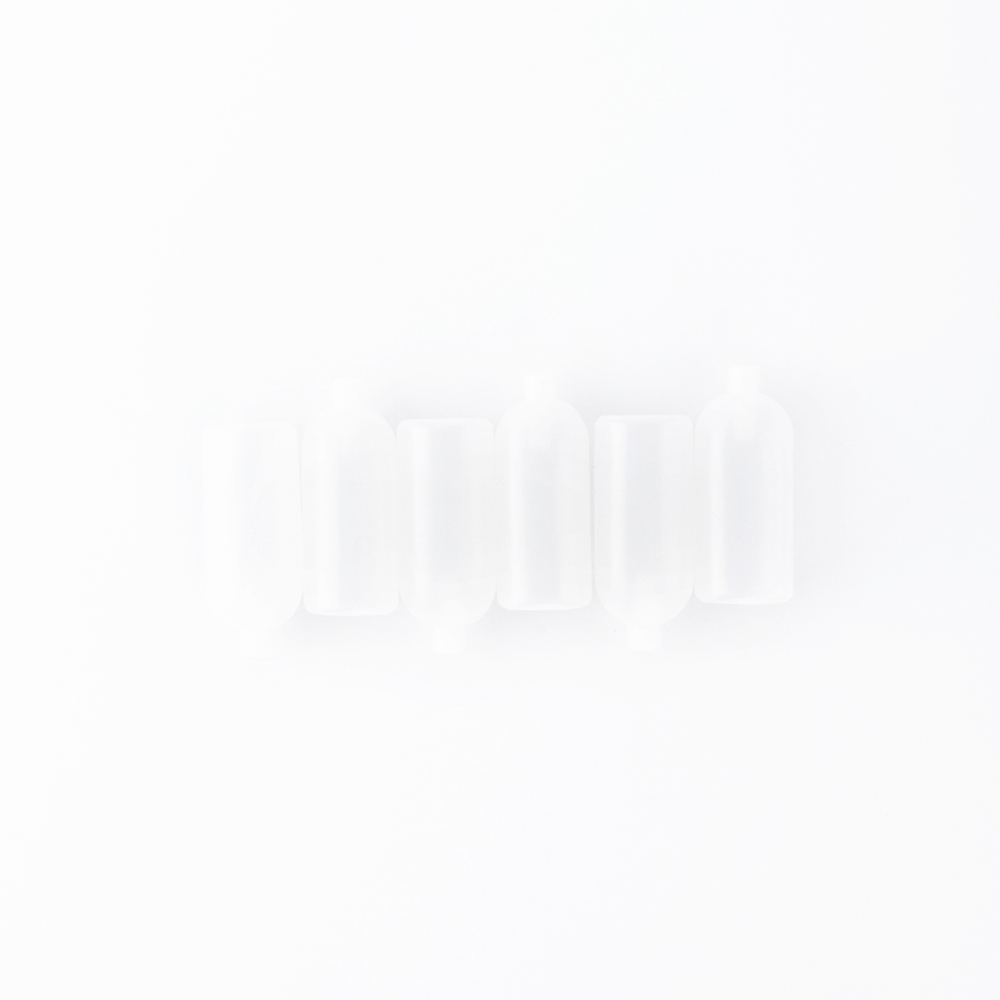 Five frosted, translucent bottles aligned horizontally on a white background.