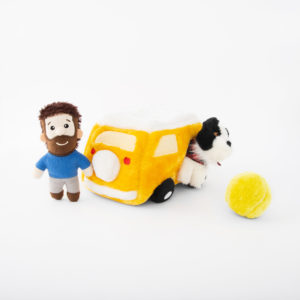 A small stuffed toy man, a plush toy van with a plush dog peeking out from the back, and a soft yellow ball are placed on a white background.