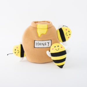 A plush honey jar with the label "HONEY" and three attached plush bees with smiling faces and black and yellow stripes.