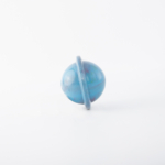 A blue, spherical bouncing toy with a ring around its middle is placed on a white background.