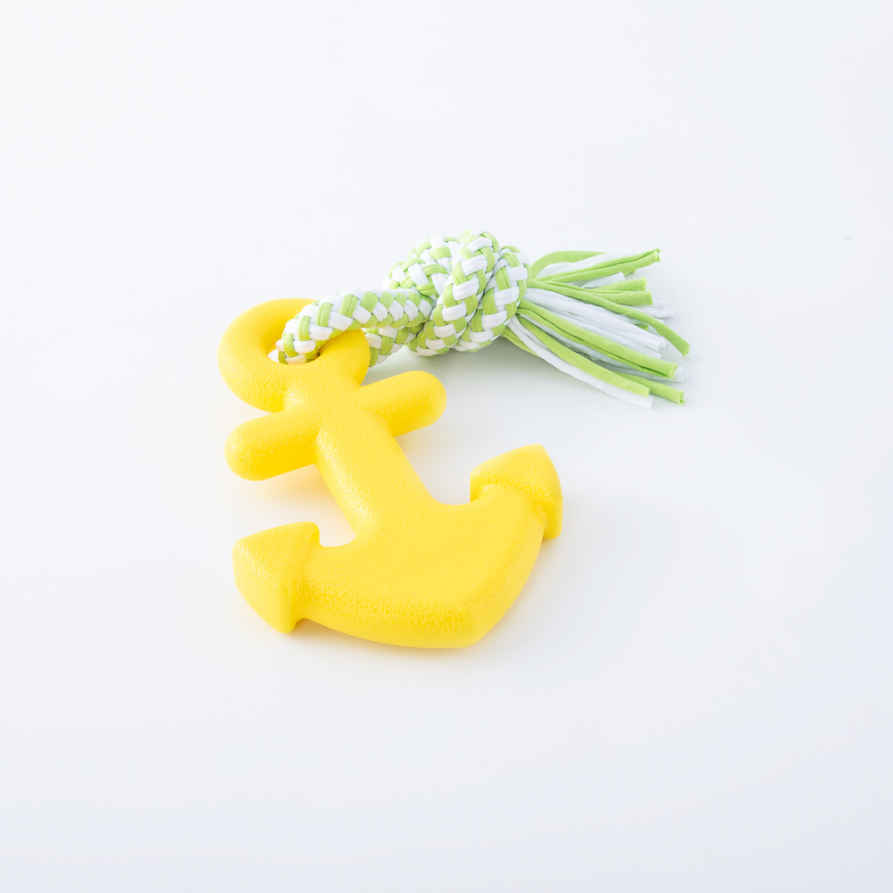 Yellow anchor-shaped dog toy with white and green rope attached on a white background.