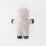 A small, fluffy toy bear with light grey fur and dark grey hands and feet, standing against a white background.
