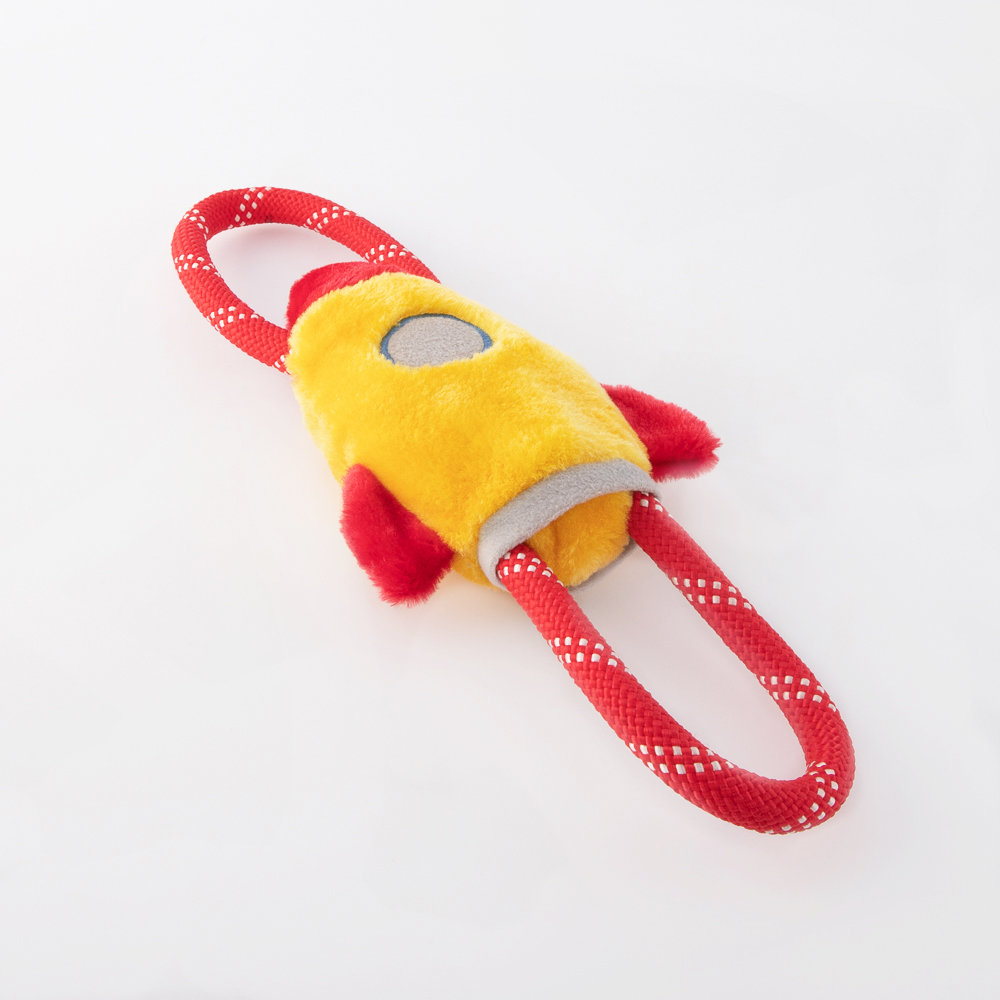 A plush dog toy shaped like a rocket, featuring a yellow body with red fins and an integrated red looped rope for easy grabbing and tugging.