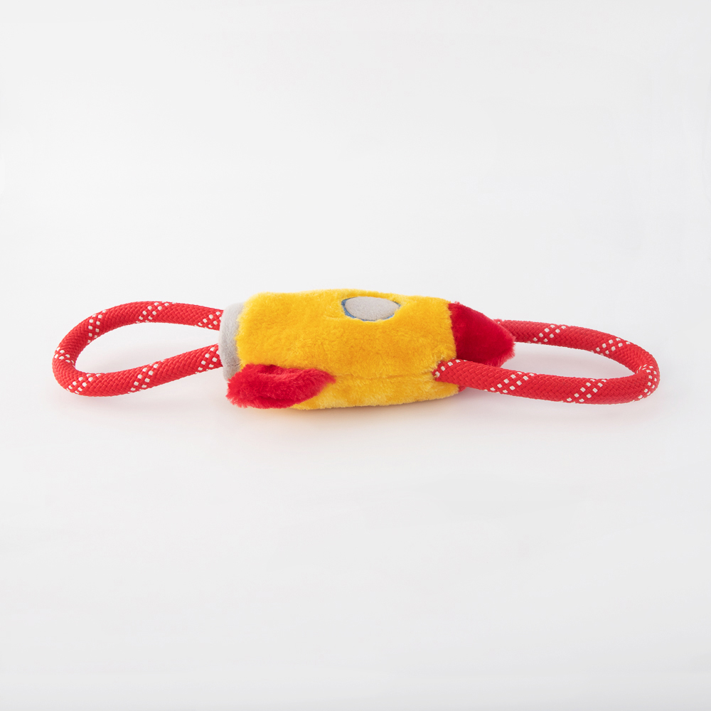 A yellow and red plush dog toy shaped like a rocket with two red and white polka-dotted loops attached at each end.