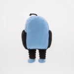 A plush toy resembling a small character with a round, blue, helmet-like head, black arms, and black legs, standing upright against a white background.