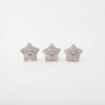 Three plush star-shaped toys with smiling faces and rosy cheeks are arranged in a row on a white background.