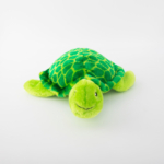 A green plush turtle with a patterned shell and a smiling face, lying on a white surface.