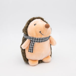 A plush toy hedgehog with a cream-colored face and body, dark brown spines, and a black and white checkered scarf.