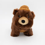 A plush toy bear wearing a striped beanie is placed against a white background.