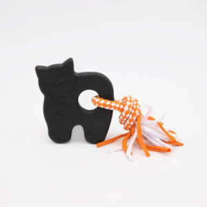 A black cat-shaped toy with a circular hole in its middle, connected to an orange and white rope with frayed ends, placed against a white background.