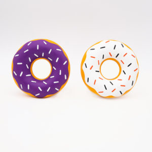 Two inflatable donut pool floats: one with purple frosting and white sprinkles, and the other with white frosting and multicolored sprinkles, set against a plain white background.