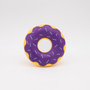 A round, yellow donut with purple icing and white sprinkles, placed against a plain white background.