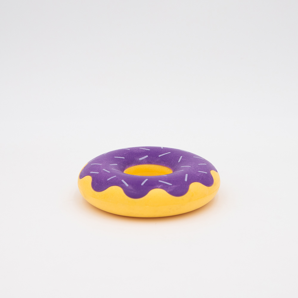 A small toy doughnut with a yellow base and purple icing with white sprinkles.