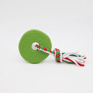 A green donut-shaped dog toy attached to a multicolored braided rope with red, white, and green strands, placed on a white background.