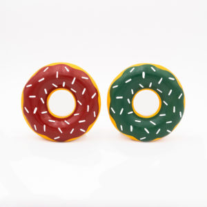 Two plastic donut toys with different colored icing and white sprinkles. One has red icing, and the other has green icing. Both have a yellow ring base.