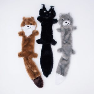 Three plush toy ferrets in brown, black, and grey, each with white accents on their faces and paws. They are laid out side by side on a white background.
