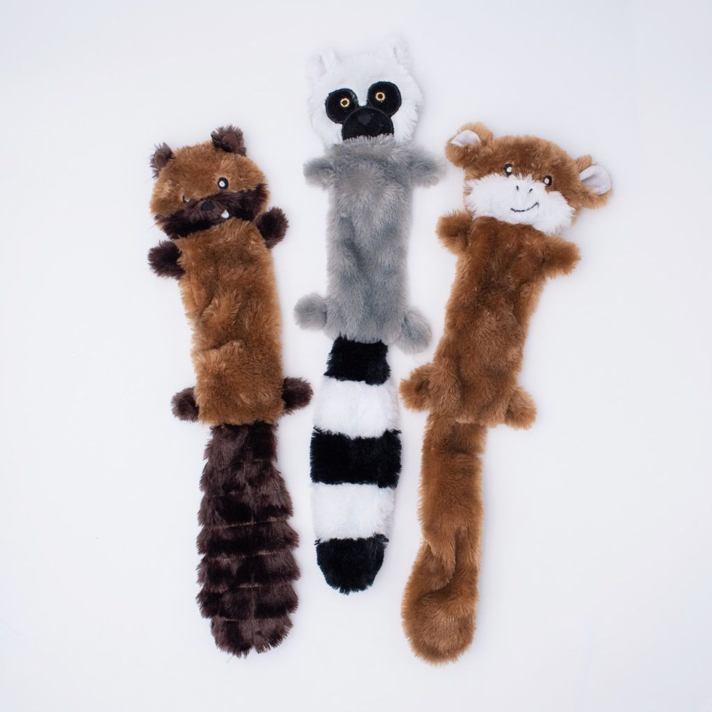 Three plush animal toys are laid out on a white background. They appear to be shaped like a raccoon, a lemur, and a monkey, each with elongated bodies and fabric textures.