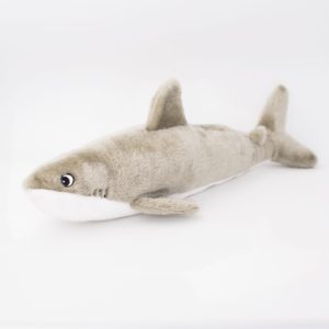 A plush toy resembling a gray shark with a white underbelly is positioned on a white background.