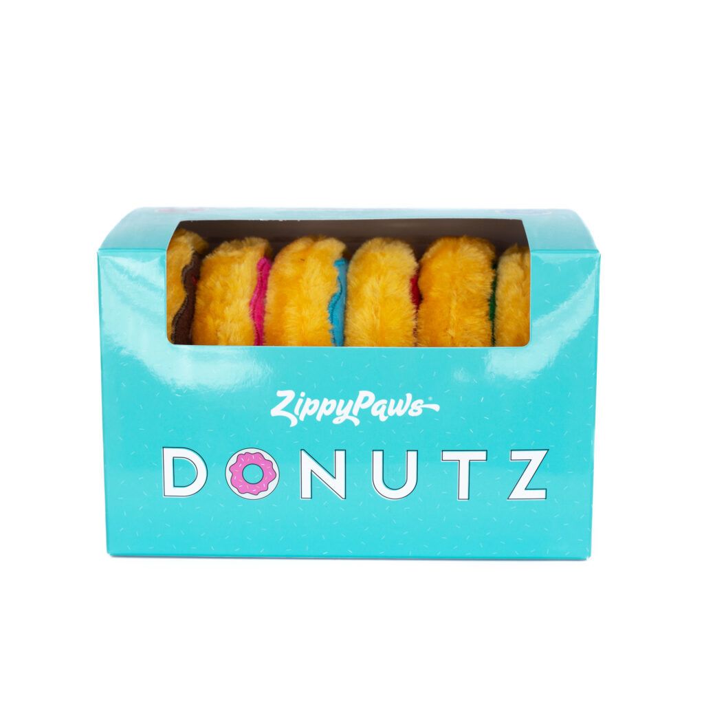 A blue box labeled "ZippyPaws Donutz" containing plush toy donuts in various colors, visible through a clear plastic window on the front of the box.