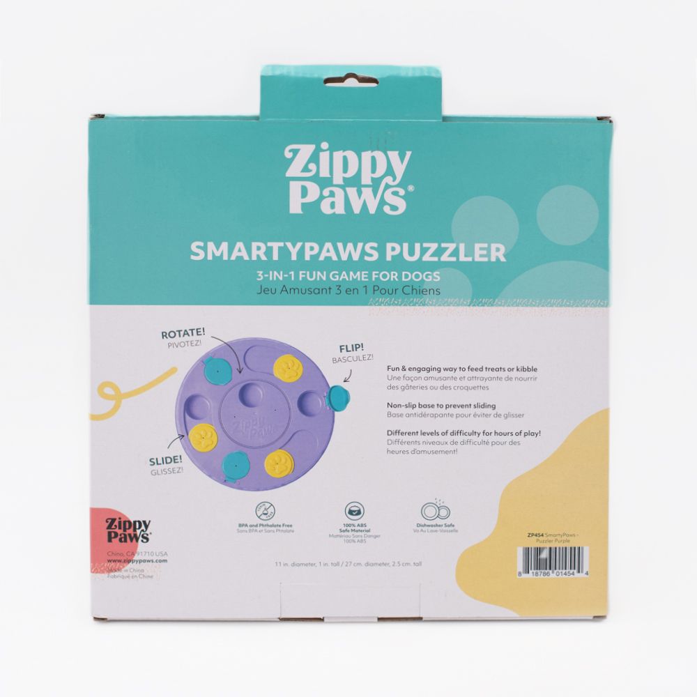 Box of SmartyPaws Puzzler Purple, a 3-in-1 interactive game for dogs, with illustrations showing rotating, flipping, and sliding features to reveal treats.