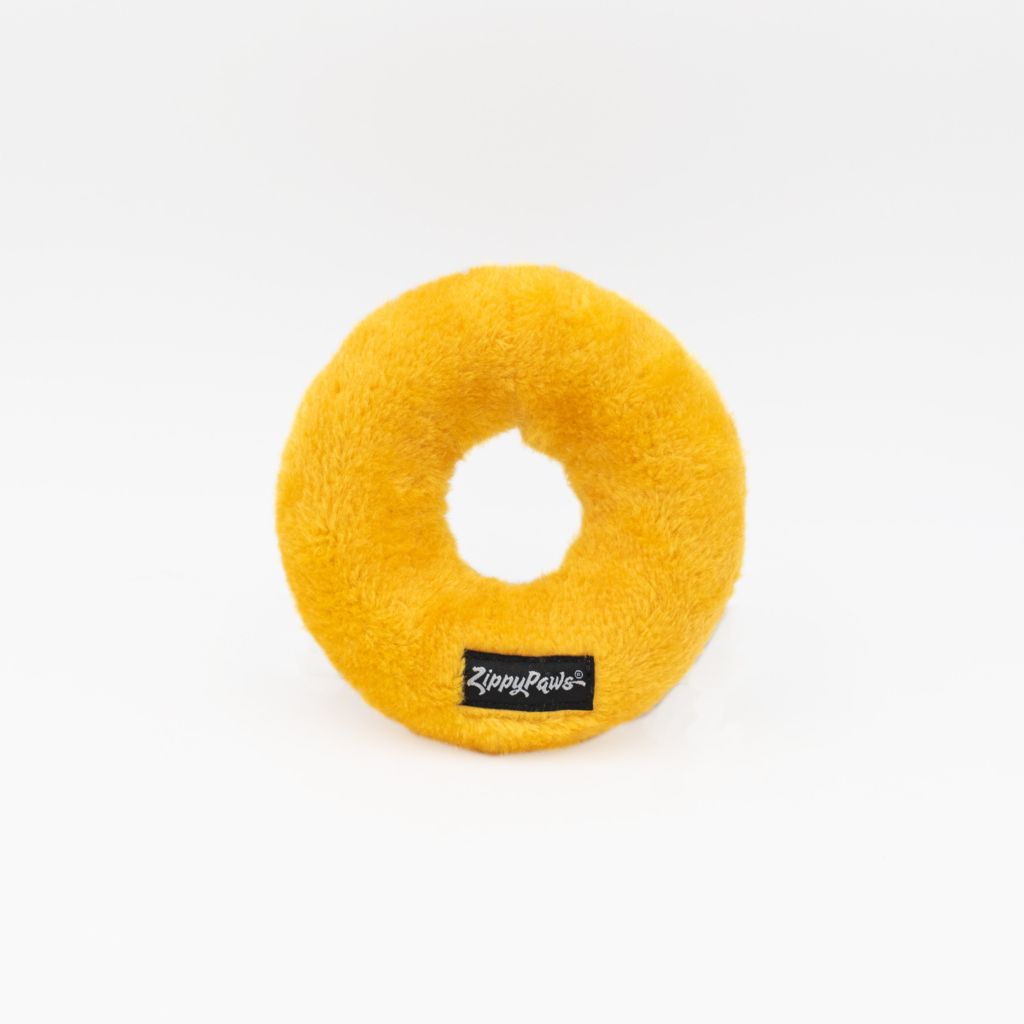 A round yellow plush dog toy with a hole in the center and a small black 
