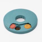 SmartyPaws Puzzler Donut Slider with small compartments covered by sliding lids, revealing treats. One compartment is open showing kibble.