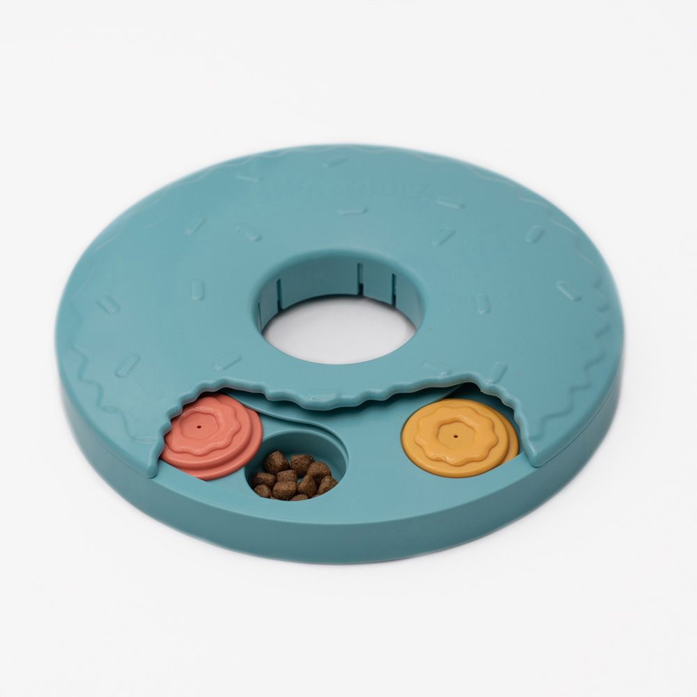 SmartyPaws Puzzler Donut Slider with small compartments covered by sliding lids, revealing treats. One compartment is open showing kibble.