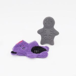 A soft purple plushie toy resembling an animal lies on its side next to a grey plastic toy shaped like Halloween Bonez - Zombie Bear on a white background.