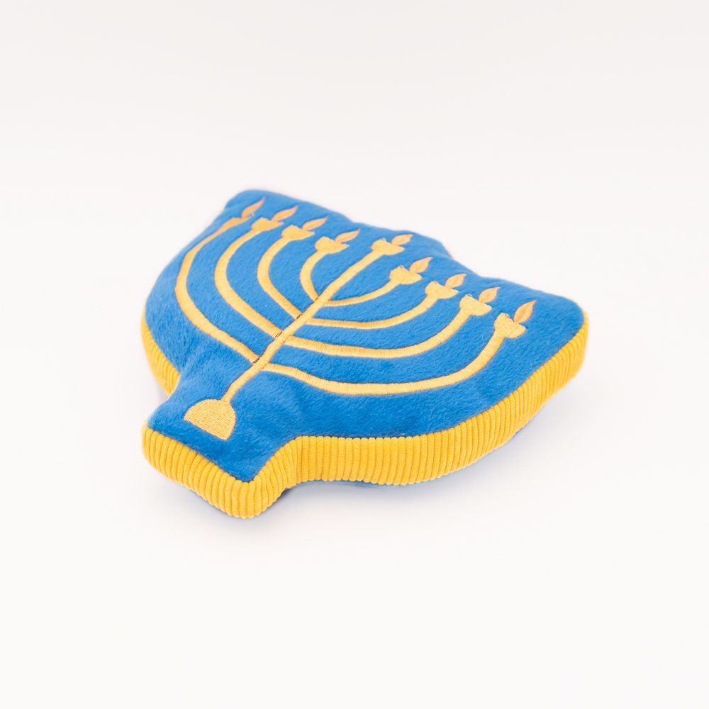 Blue plush Hanukkah Squeakie Pattiez - Menorah with yellow embroidery showing nine candle holders, lying on a white surface.