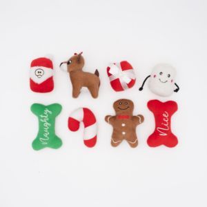 A collection of Holiday Miniz Multipack 8-Pack Christmas-themed plush toys, including a Santa, reindeer, candy cane, gingerbread man, and various shapes labeled "Naughty" and "Nice," arranged on a white background.