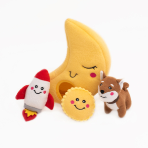 A Zippy Burrow® - To the Moon, with a smiling face, a plush rocket, a round plush sun, and a plush brown and white dog, all with cheerful expressions, are arranged on a white background.
