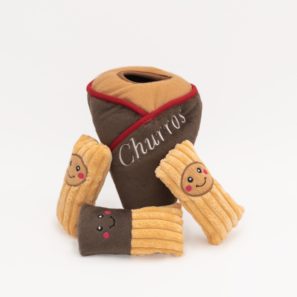 Plush churro toys with smiling faces are displayed next to a plush container labeled 