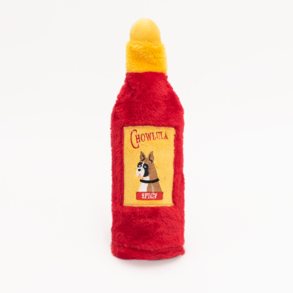 A plush toy shaped like a hot sauce bottle labeled 