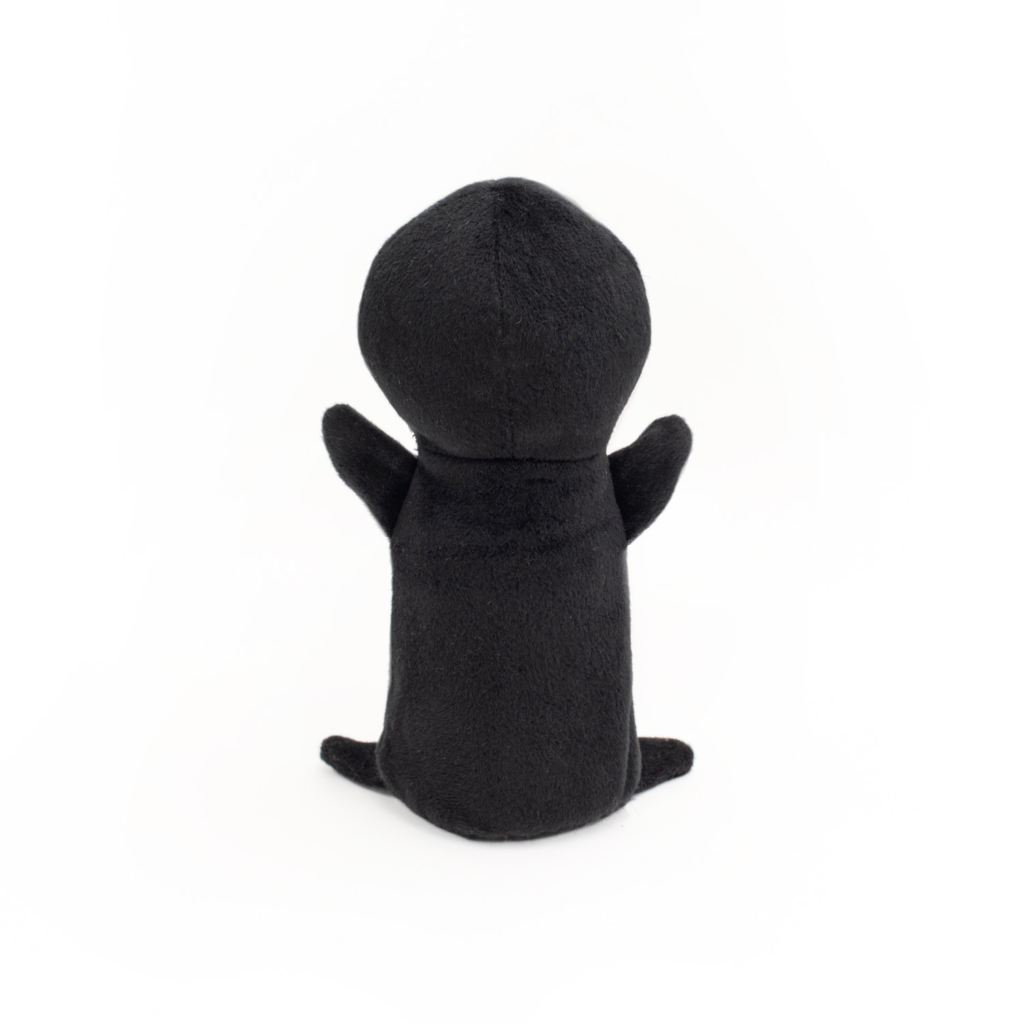 A black, soft Halloween Colossal Buddie - Witch standing upright with no distinct facial features, viewed from the back against a white background.