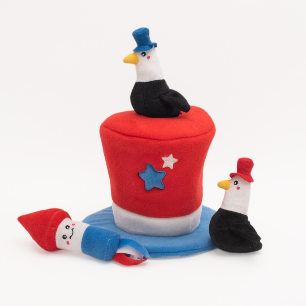 Zippy Burrow® - Americana Top Hat with a red, white, and blue hat and three toy figures wearing red and blue hats, two resembling birds and one resembling a gnome.