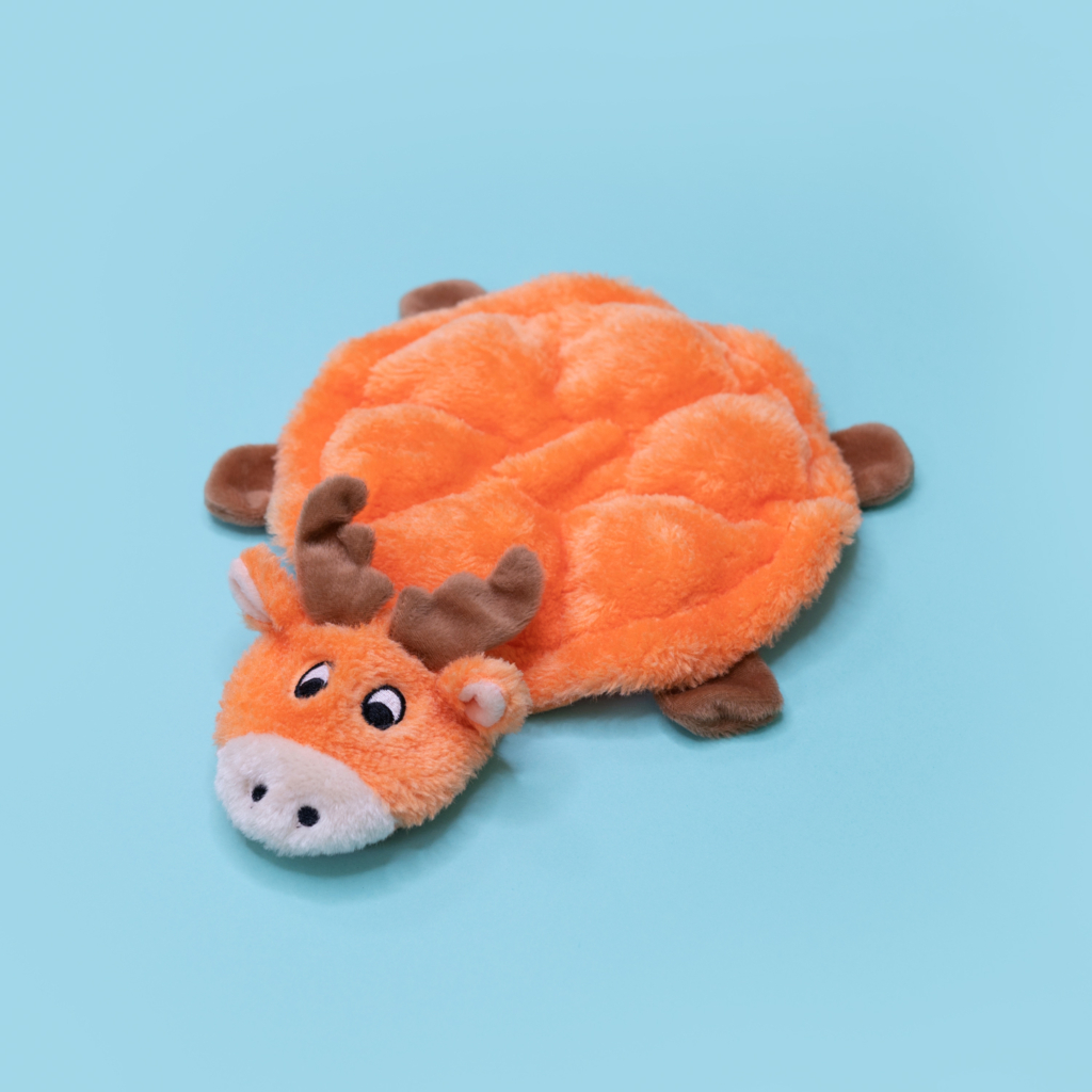 A soft, orange plush toy in the shape of a flat moose lies against a light blue background.