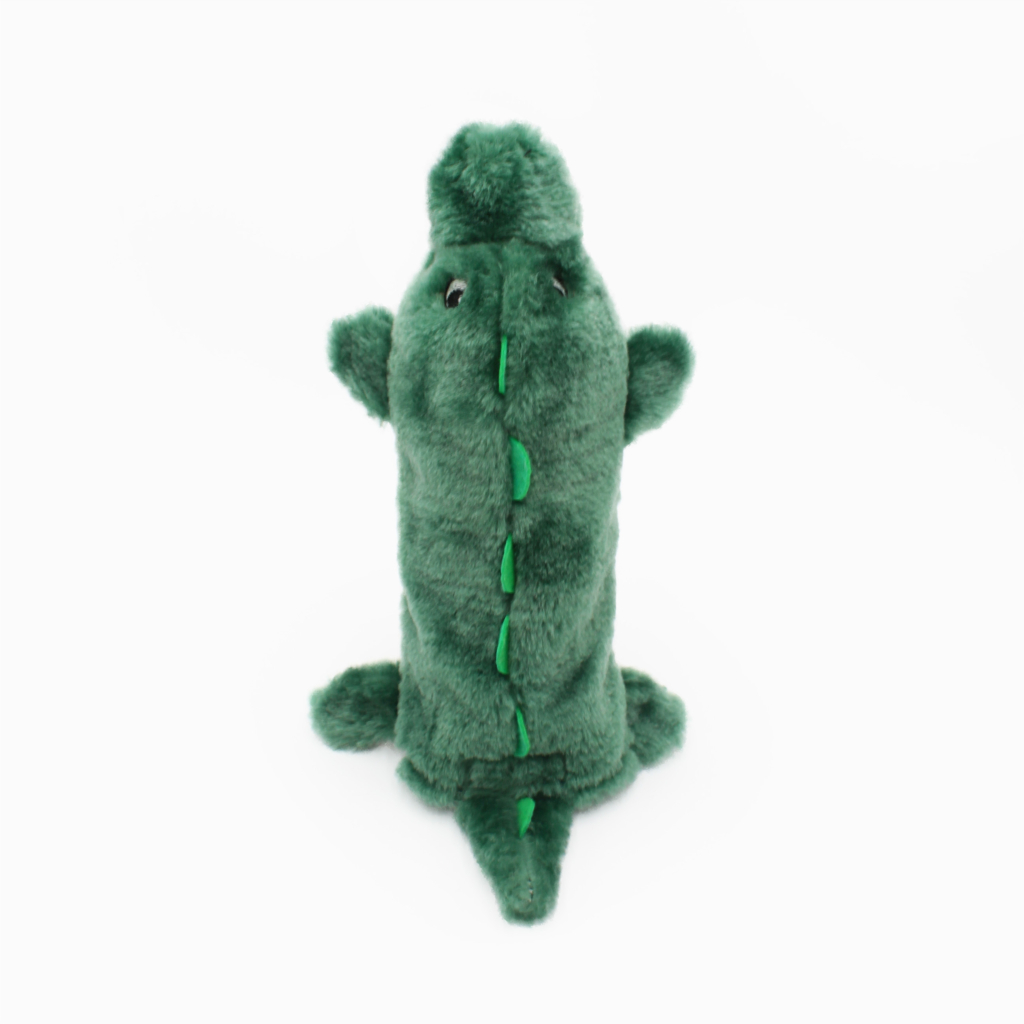 Plush green toy crocodile standing upright with small limbs and a textured surface.
