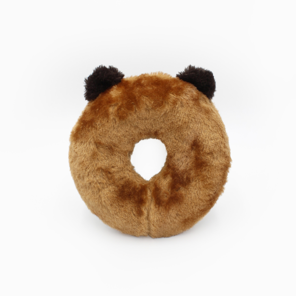 A round, plush, light brown doughnut-shaped pillow with two dark brown, bear-like ears on top.
