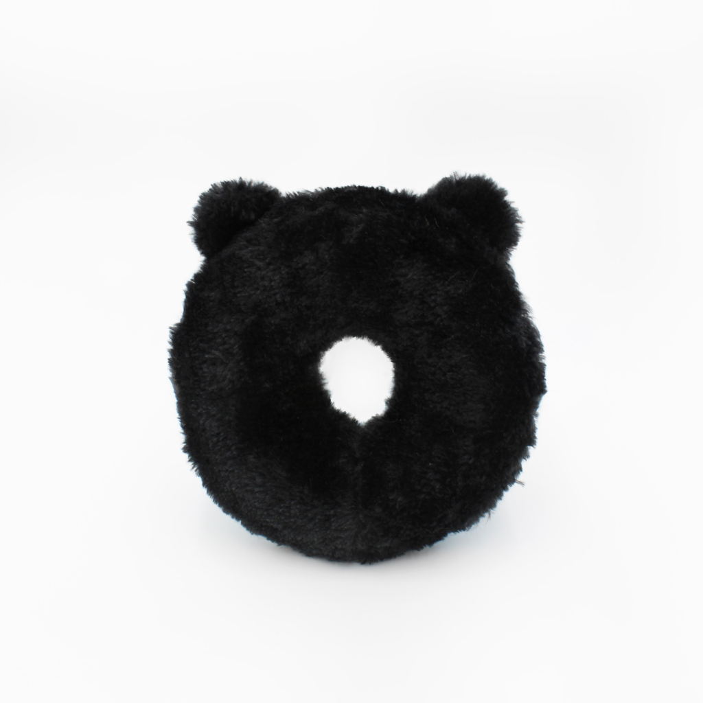 A black, circular plush pillow with two small round protrusions resembling ears, and a hole in the center.