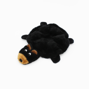 A black plush dog toy in the shape of a turtle with a brown, black-eyed dog face and four flat legs.